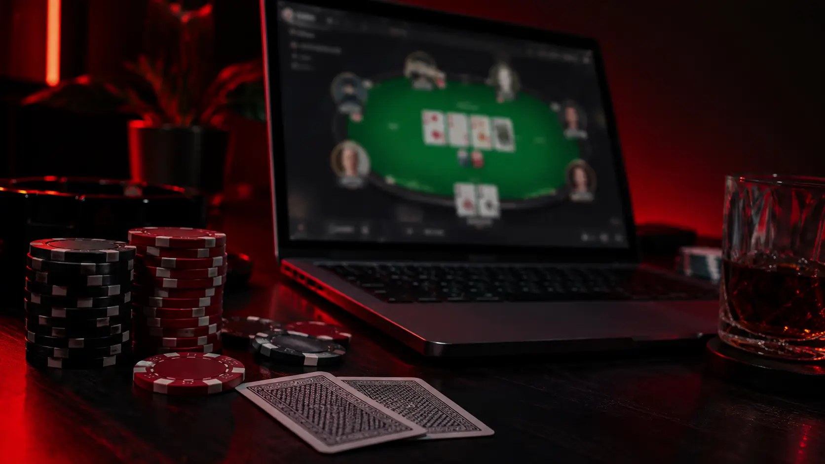 Online-pokker sülearvutis, kõrval pokkeri žetoonid ja mängukaardid